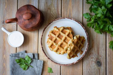 Öğle yemeği için doyurucu bir atıştırmalık: beyaz tabakta kalın patates waffle 'ı. Üst görünüm