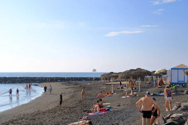 20 Kasım 2021 - Kosta Adeje, Tenerife, İspanya: Turistler dinleniyor ve siyah plajda oynuyorlar