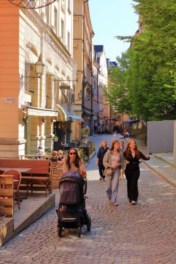 24 Mayıs 2022 - İsveç 'te Stockholm: Riddarholmen' de kaldırımda yürüyen turistler Gamla Stan 'in bir parçasıdır.