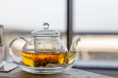 Doğal bitki çaydanlığıyla şeffaf bir çaydanlığın yakın çekimi. Alternatif tıp. Sağlık hizmetleri. Sağ tarafta bir metin eklenecek yer, boşluğun bir kopyası. 