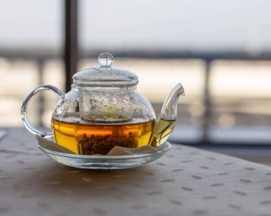 Havaalanındaki bir kafede masanın üzerinde sıcak bitki çayı olan bir çaydanlık var. Kullanışlı bir şekilde harcanan zamanı beklemek. Sağlık hizmetleri.