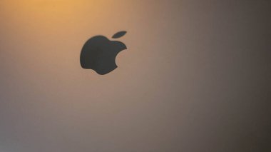 Close-up of the apple logo of a shiny reflective symbol. Grey laptop. Laptop for office work and freelancing. A yellow light is shining from top left. December 4 Belarus Minsk
