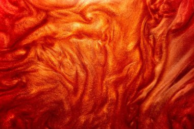 Defoktus. Soyut detaylı kırmızı, turuncu ve parıltılı parçacıklar su altında akıyor. Sudaki ışıltının hareketi kırmızıdır. Büyülü, pırıl pırıl bir arka plan..