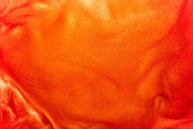 Defoktus. Suda parlak kırmızı, turuncu parlak renk parçacıkları. Parlak kırmızı rengin soyut arkaplanı. Işıltı suyun altında hareket ediyor. Neşeli, parlak, ışıltılı.