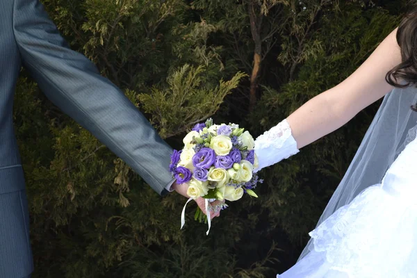 Nevěsta a ženich drží kytici — Stock fotografie