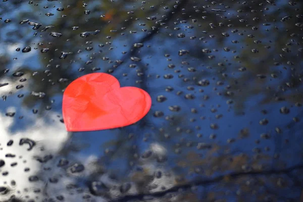 Bilden av hjärtat på en blå bil huva och regn droppar — Stockfoto