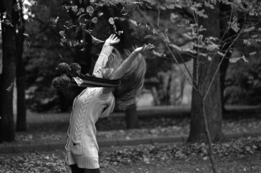 park sonbahar yaprakları atan kız