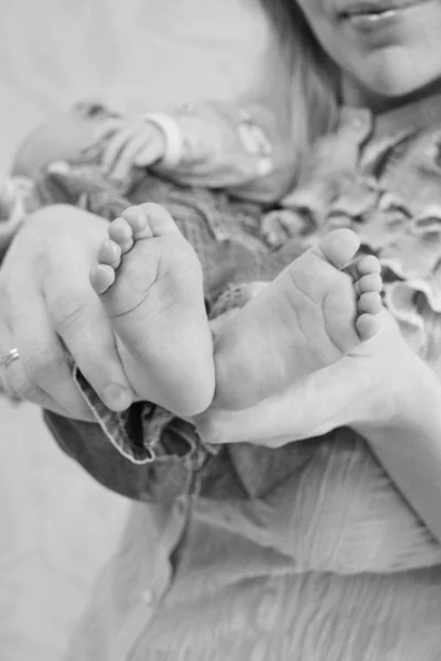 Manos y pies de un bebé recién nacido en las manos de la madre en blanco y negro —  Fotos de Stock