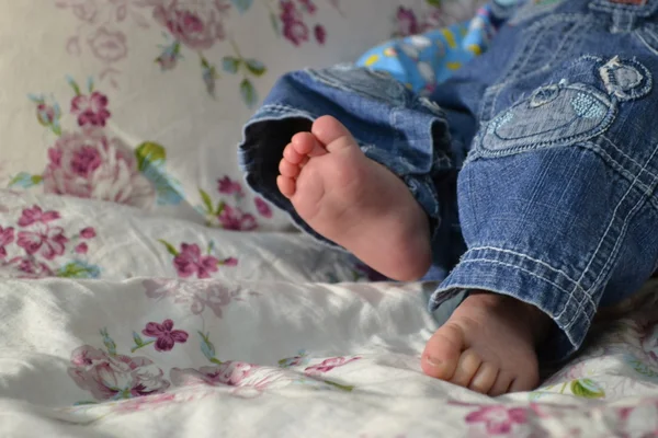 Bebé pies en cuna Fotos de stock