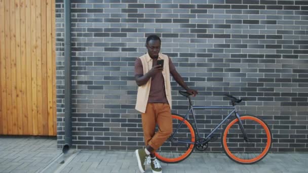 Jovem Afro Americano Rua Com Bicicleta Usando Smartphone Enquanto Pessoas — Vídeo de Stock
