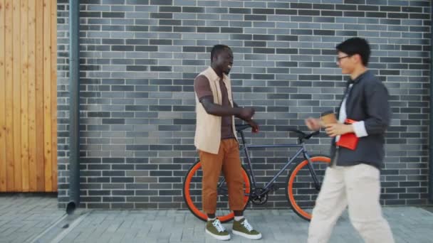 길에서 자전거를 아프리카 미국인 그리고 주먹을 아시아 친구와 인사를 나누고 — 비디오
