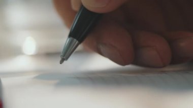 Defterde kalem tutan tanınmayan adamların son derece yakın çekim görüntüleri var.