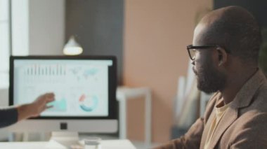 Modern ofiste yeni bir proje için finans stratejisi üzerinde çalışan iki genç adamın yatay çekim görüntüleri.