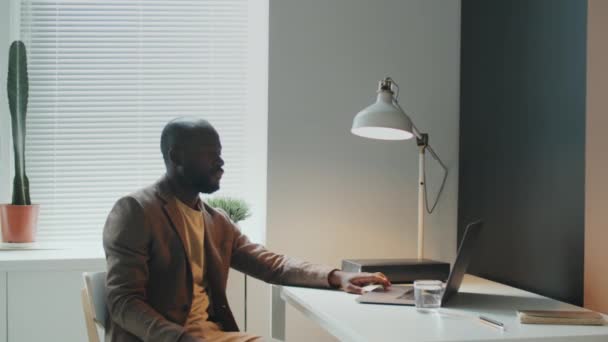 Poziomy Portret Młodego Afroamerykanina Siedzącego Zrelaksowanego Biurze Oglądającego Coś Laptopie — Wideo stockowe