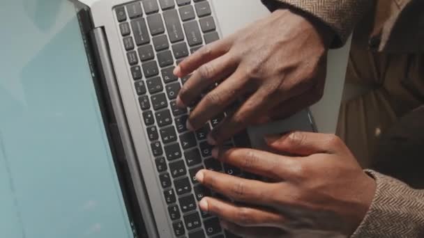 上のビューからの水平認識できない黒人男性の手ノートパソコンのキーボードにテキストを入力するのクローズアップショット映像 — ストック動画