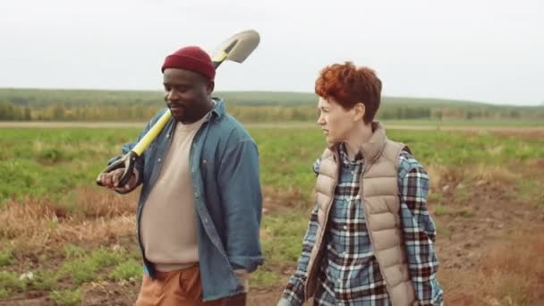 Strzał Górę Białej Kobiety Trzymającej Wiadro Rozmawiającej Afroamerykaninem Niosącym Łopatę — Wideo stockowe