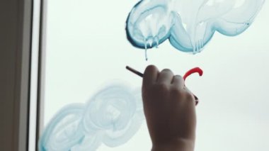 Evi dekore ederken pencerenin camına kırmızı kalp çizen tanınmayan bir kadının ellerini yakın plan yap.