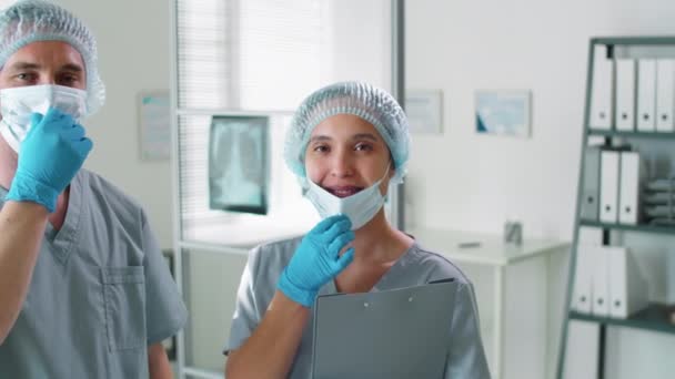 Χαρούμενες Γυναίκες Και Άνδρες Γιατροί Προστατευτικές Στολές Αφαιρούν Μάσκες Προσώπου — Αρχείο Βίντεο