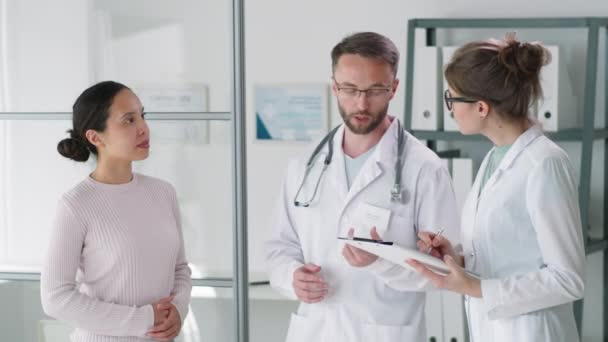 Mužský Lékař Laboratorním Plášti Brýlích Stetoskopu Krku Mluví Pacientkou Zatímco — Stock video