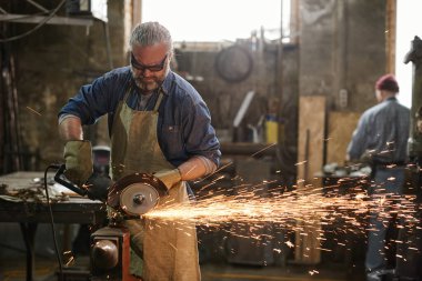 Metali aletle kesen işçiler
