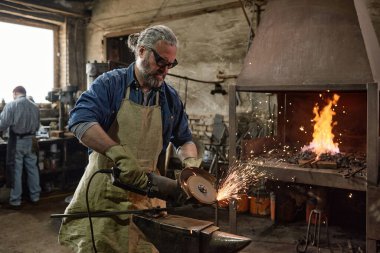 Marangoz atölyede öğütücüyle çalışıyor.