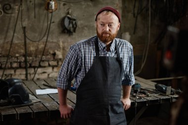 Zanaatkar atölyede duruyor.