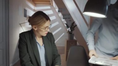 360 derecelik güzel sarışın iş kadını ve erkek ortadoğulu meslektaşın proje üzerinde çalışırken ofis masasında dokümanları tartışırken çekimleri.