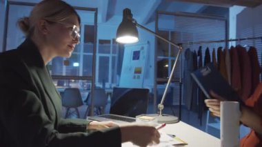 360 derecelik, genç bir ortadoğu erkek tasarımcısının ofise girerken, bayan meslektaşıyla el sıkışırken ve gece moda koleksiyonu üzerinde çalışırken projeyi tartışırken.