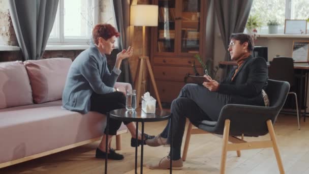 Ampliar Toma Una Mujer Deprimida Sentada Sofá Conversando Con Psicólogo — Vídeos de Stock