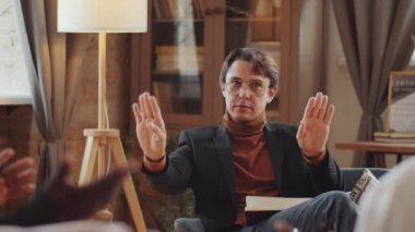 Kafkasyalı psikolog terapi seansı sırasında Afrikalı Amerikalı çiftlerle konuşuyor.