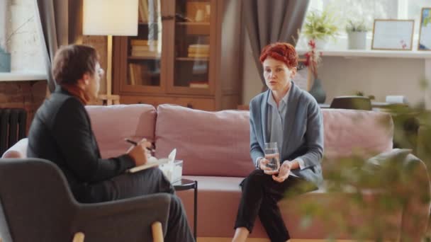Mladá Běloška Sedící Pohovce Pitná Voda Diskutující Psychologem Během Terapie — Stock video