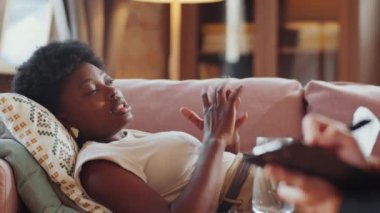 Afrika kökenli Amerikalı bir kadın kanepeye uzanıp psikologlara danışmanlık sırasında sorunlardan şikayet ediyor.