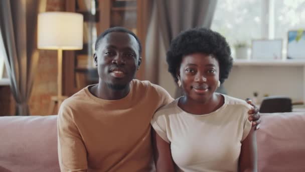 Retrato Una Feliz Pareja Afroamericana Sentada Sofá Abrazando Mirando Cámara — Vídeos de Stock