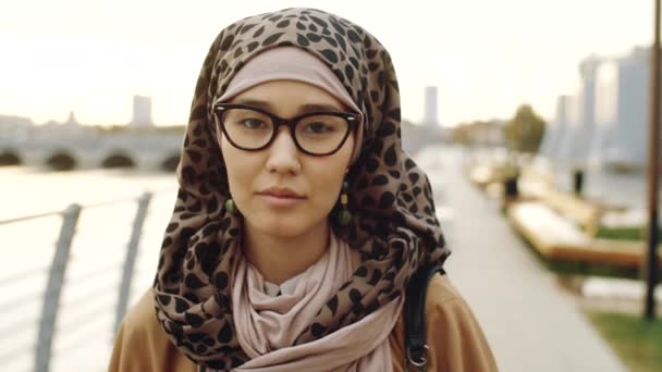 年轻的中东穆斯林妇女头戴头巾 看着相机 白天站在室外的肩式防弹背心 — 图库视频影像