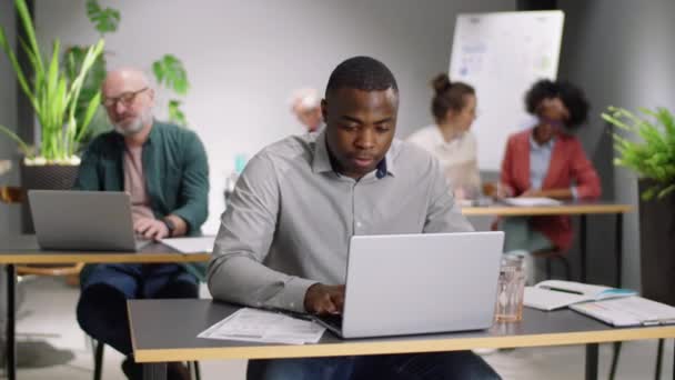 Junger Fröhlicher Afroamerikanischer Mann Arbeitet Laptop Schreibtisch Blickt Dann Die — Stockvideo