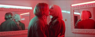 Eski moda banyoda öpüşen şehvetli genç çiftin belini kaldırın. Kırmızı neon ışıkla dolu.