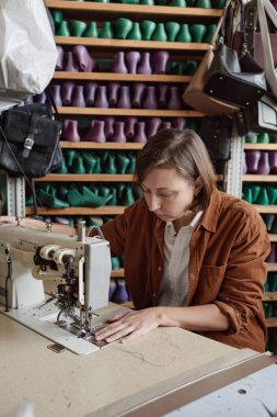 İşyerinde dikiş makinesi kullanan terzi.