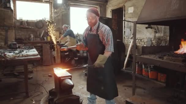 Blacksmith Hammering Hot Metal Anvil Workshop While His Colleague Working — Stock Video