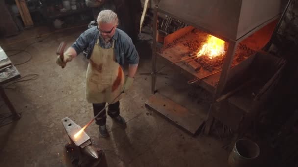 Hochwinkelaufnahme Des Schmieds Schürze Schutzbrille Und Handschuhe Die Beheizte Eisenstange — Stockvideo