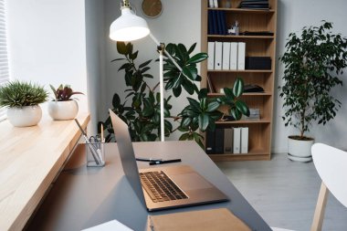 Ofisinde dizüstü bilgisayarı olan modern işyeri