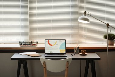 Ofisinde dizüstü bilgisayarı olan modern işyeri