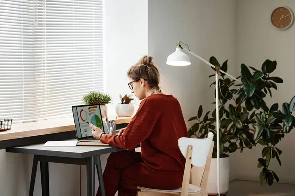 Женщина, работающая с финансовыми картами на ноутбуке — стоковое фото