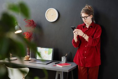 Telefonda mesaj okuyan bir kadın.