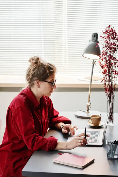 Kvinna som använder laptop i sitt arbetsrum — Stockfoto