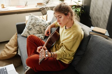 Odada gitar çalan kadın.
