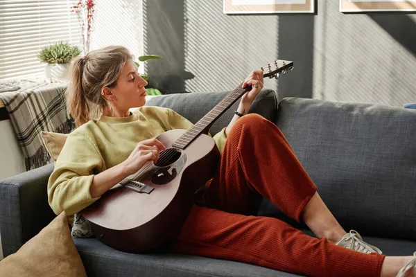 Evde gitar çalan kadın.