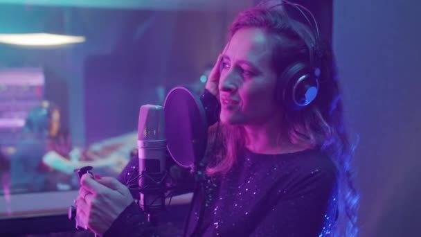 Hermosa Mujer Caucásica Auriculares Cantando Micrófono Estudio Grabación Con Luz — Vídeo de stock