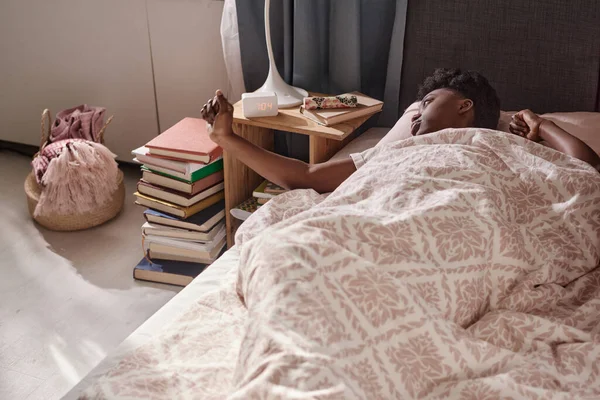 Mulher acordando com despertador no quarto — Fotografia de Stock