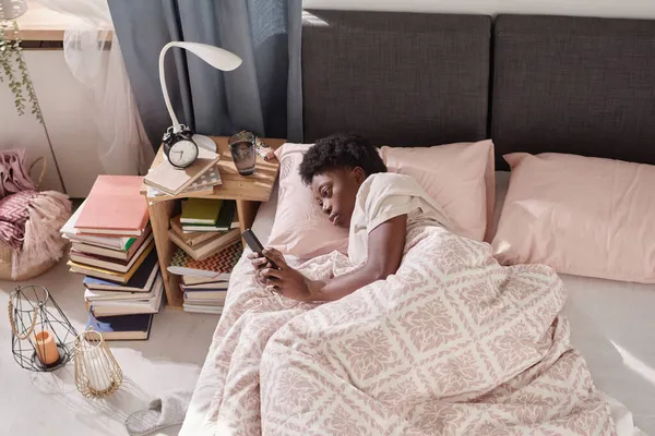 Vrouw met telefoon in de slaapkamer — Stockfoto