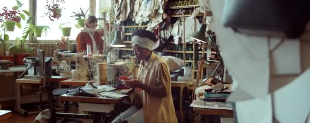 Ung Afroamerikansk Kvinnlig Skomakare Arbetar Med Läder Vid Skrivbordet Medan — Stockvideo